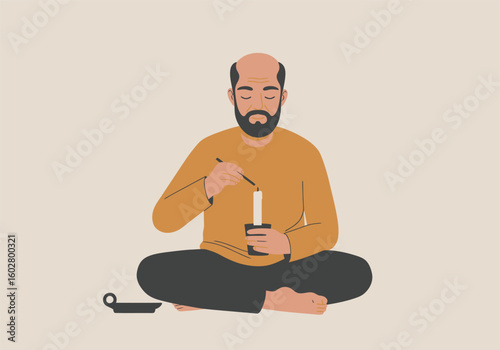 Bald man in meditation, lighting a candle, seated on the floor.