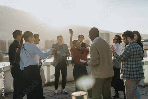 Obraz na płótnie A group of diverse business colleagues enjoy a celebration with music and dance on a rooftop, enjoying the sunset