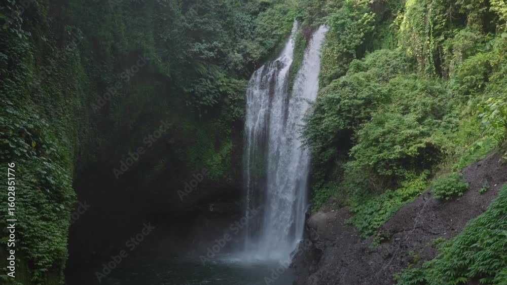Aling-Aling Waterfall cascades through lush green cliffs in northern Bali. A serene, tropical jungle scene ideal for nature, travel, and adventure content. Aling-Aling Waterfall cascades through lush green cliffs in northern Bali. A serene, tropical jungle scene ideal for nature, travel, and adventure content.