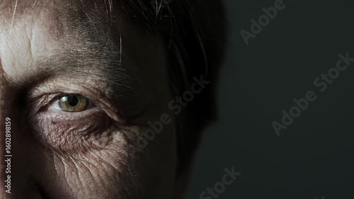 Portrait of senior woman. Macro view of aging skin around the eyes, showing fine lines and wrinkles. Concept of natural aging, dermatology, and realistic human beauty.