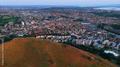 Aerial video of a Beautiful Sunrise over the city of Edinburgh - Scotland, featuring the hills of Holyrood Park. 