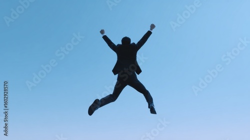 Wallpaper Mural A man in a suit is jumping in the air with his arms raised Torontodigital.ca