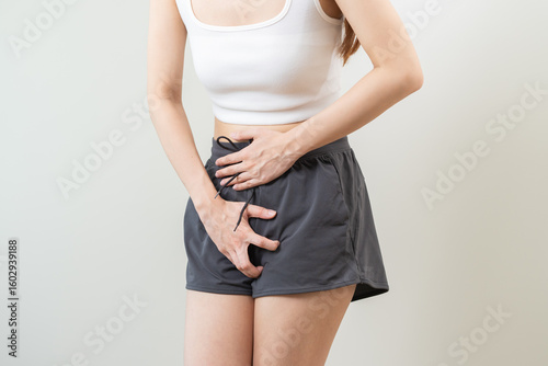 Photos woman having painful lower stomach and hands holding pressing her crotch lower a