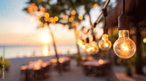 Golden evening light reflecting on outdoor dining tables with soft string light bokeh