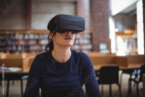 Virtual reality headset resting on wooden study table in spacious library with natural light