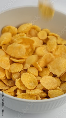 Corn flakes cereal breakfast falling down in bowl