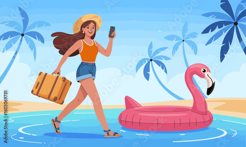 A woman in summer attire walks along a beach with a suitcase and phone, near a flamingo float in the water.