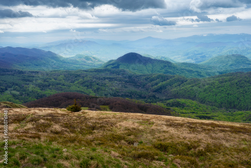Fototapeta Naklejka Na Ścianę i Meble -  Breathtaking panoramic view from Halicz in Bieszczady Mountains, Poland, showcasing the Orthon effect, forested hills, distant peaks, and moody cloudscapes