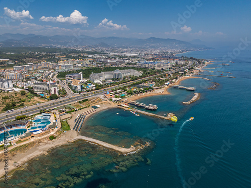 Fototapeta Naklejka Na Ścianę i Meble -  Stunning aerial day view over Turkler in Alanya, Turkey. Alanya coastline,resorts,marina,hotels and crystal clear turquoise water along the Mediterranean Sea. Mediterranean Sea turquoise coastline.