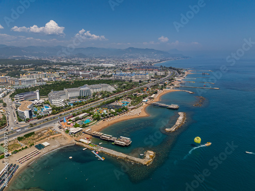 Fototapeta Naklejka Na Ścianę i Meble -  Stunning aerial day view over Turkler in Alanya, Turkey. Alanya coastline,resorts,marina,hotels and crystal clear turquoise water along the Mediterranean Sea. Mediterranean Sea turquoise coastline.