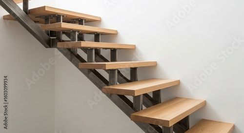 Modern staircase with floating wooden steps and a central metal stringer against a white wall.