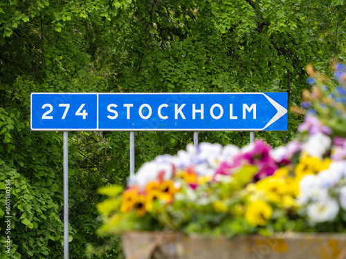 Canvas Print Road Sign to Stockholm with Colorful Flowers