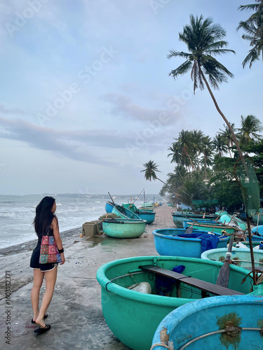woman walking on the beach in vietnam fishermans village on coast in early morning