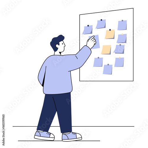 Young man arranging sticky notes on a board in a modern workspace  