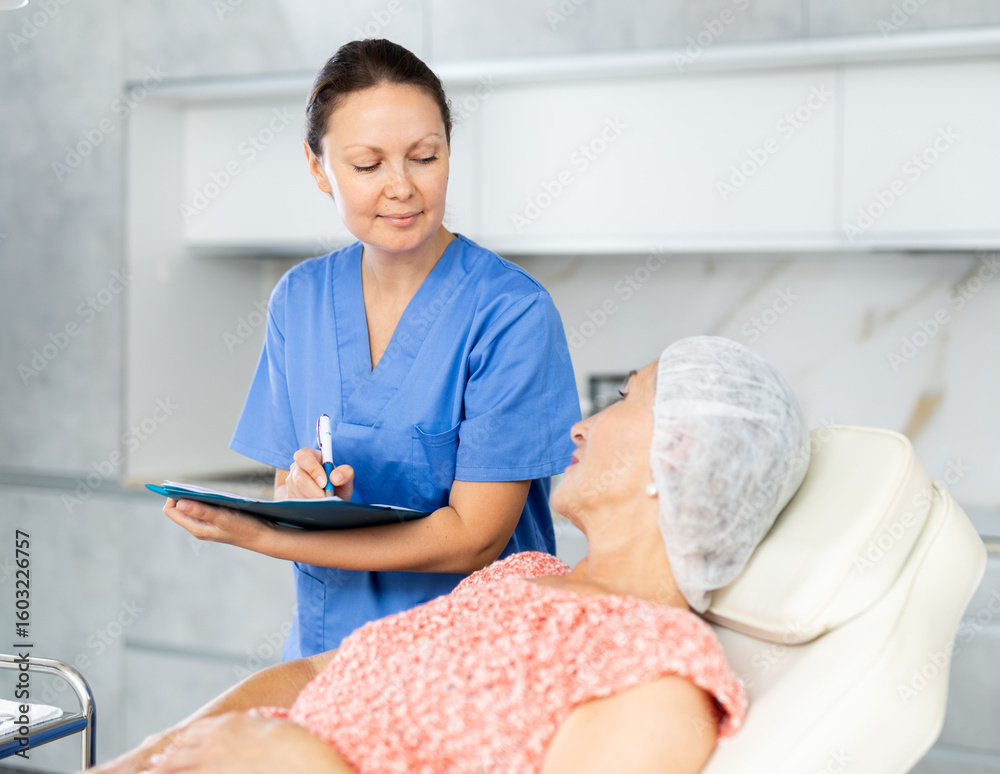 Obraz premium Female cosmetologist writes down the complaints of female patient in a cosmetology clinic