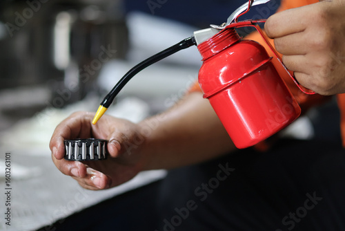 Fotografie Close up male hand lubricating bearings with oil can