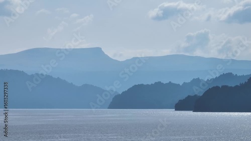 Lake Moquehue surrounded by mountains under cloudy sky. Neuquen, Argentina