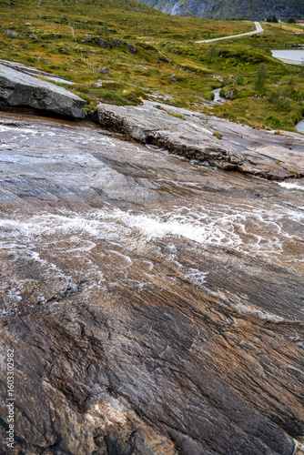 Dynamic Mountain Stream Cascading Over Polished Rock Formations in Lush Green Nordic Landscape - Nature's Erosion Art