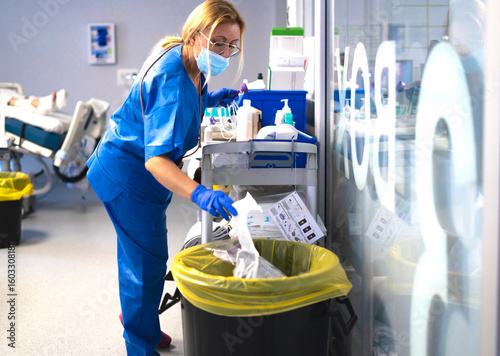 Nurse disposing of medical waste in hospital room