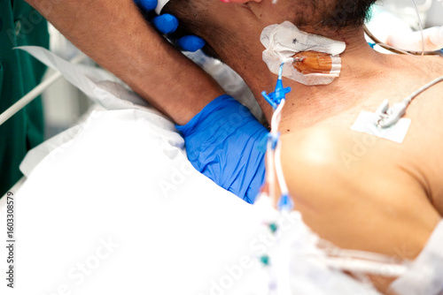 Photos Doctor checking central venous catheter of patient in hospital