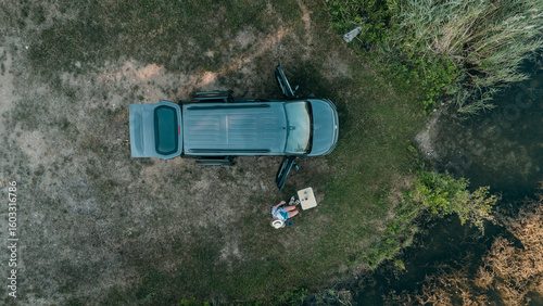 Fotografie Aerial view of mini campervan wild camping by a lake in Bavaria surrounded by na
