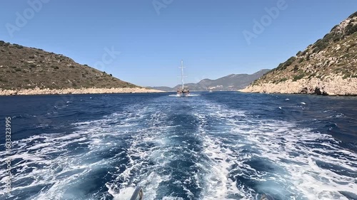 Boat tour in Kaş, Kekova and Kaleköy. Boats moving through the deep blue sea, leaving white foam behind. Antalya
