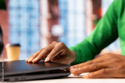 Vászonkép Teleworker at home office desk closing laptop lid after finishing editing files
