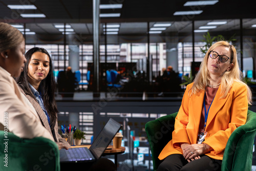 Slika na platnu Diverse businesswomen trying to discuss with disconnected detached CEO, suffering from depersonalization and apathy because of burnout
