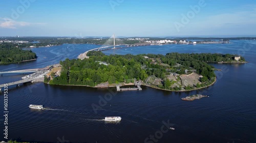 Wallpaper Mural Aerial drone footage of Korkeasaari Island in Helsinki, Finland, on a summer day, showing a tour boat gliding across calm waters and the surrounding island landscape. Torontodigital.ca