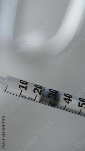 Syringe drawing liquid solution for medical use. Clear measurement markings ensuring accurate preparation. Healthcare and pharmaceutical concept. Disease prevention and treatment approach