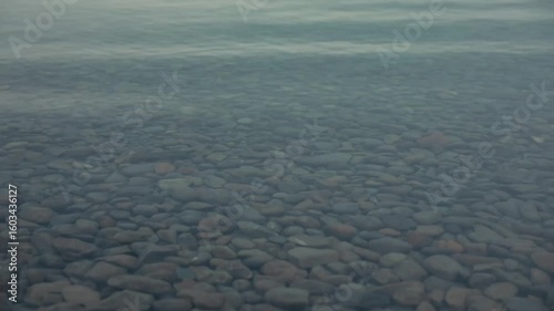 Close up of a calm lake on a rocky bed