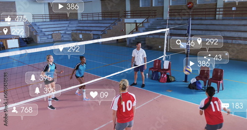 Competing players in blue and red jerseys spiking volleyball at school gym, with net, icons