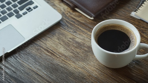 Laptop, coffee, and notebook on a wooden table