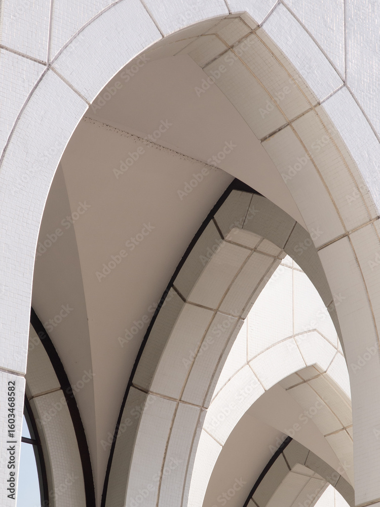 Fototapeta premium Archway of a white building with lines and shadows.
