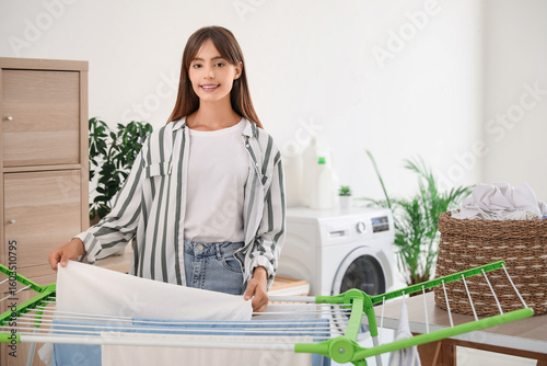 Young woman hanging clean c...