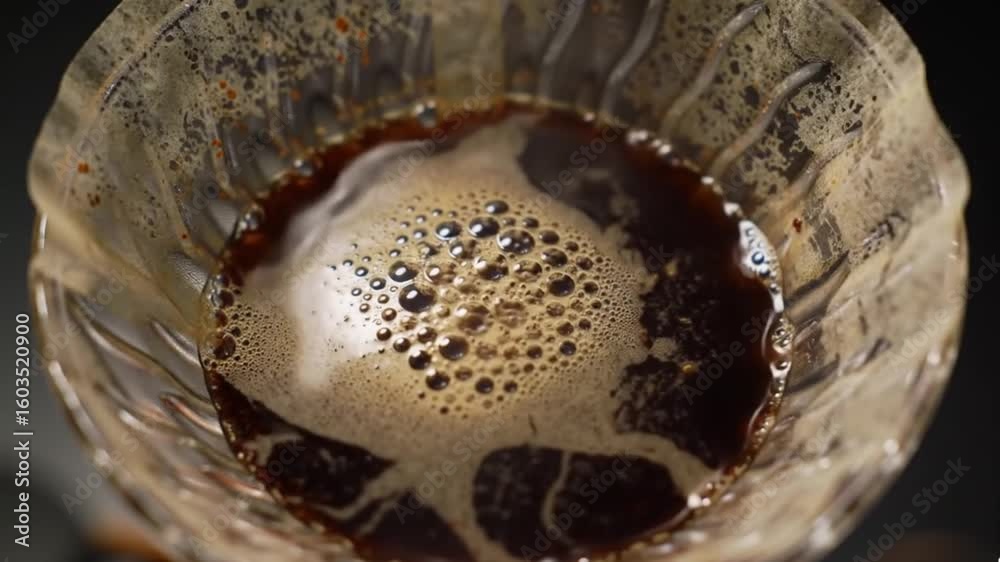 Close-up of hot water being poured onto coffee grounds in a V60 dripper.