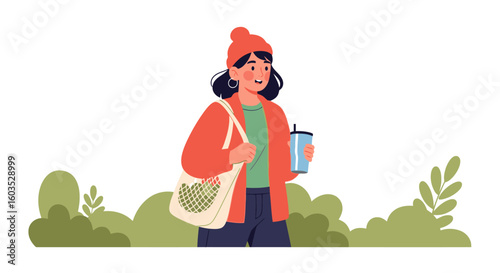 Stylish woman with reusable bag and drink enjoys a casual stroll through nature