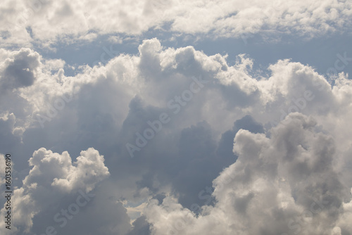 Φωτογραφία Thick, billowing cumulus clouds tower in the sky, partially illuminated by sunlight, creating a dramatic and dynamic weather scene