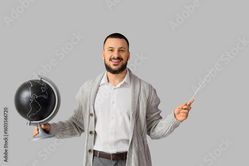 Male Geography teacher with globe and pointer on light background