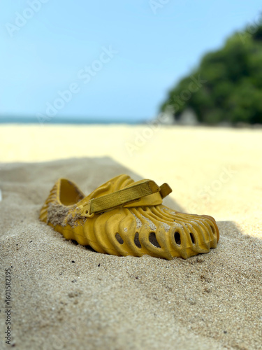 Chancla amarilla sobre playa