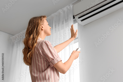 Young woman near air condit...
