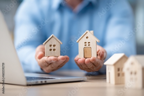 Wallpaper Mural Hands hold small wooden houses over a laptop Torontodigital.ca