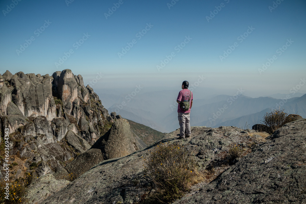 Fototapeta premium Male person in trekin clothing standing looking at the horizon in the Marcahuasi mountain chasm.