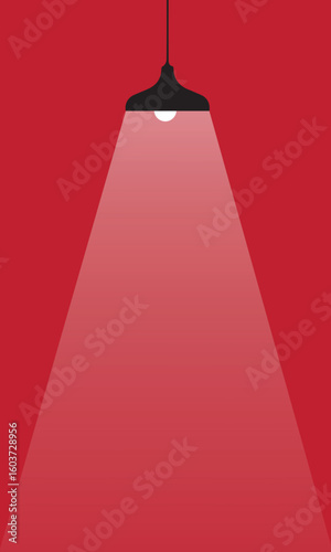 Hanging pendant lamp casting a bright spotlight for focus and ideas on a red background