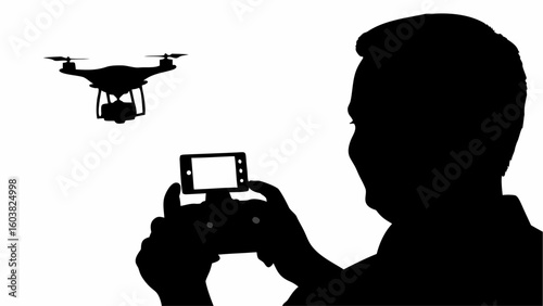 Silhouette of a man operating a drone with a smartphone controller in a stark black and white image view