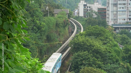 Chongqing light rail trains navigate through residential buildings and lush greenery