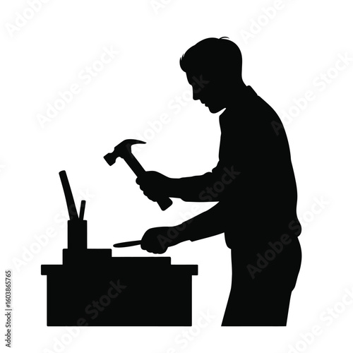 Silhouette of a man hammering a chisel on a workbench