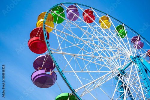 Ferris wheel with colorful cabins against a clear sky