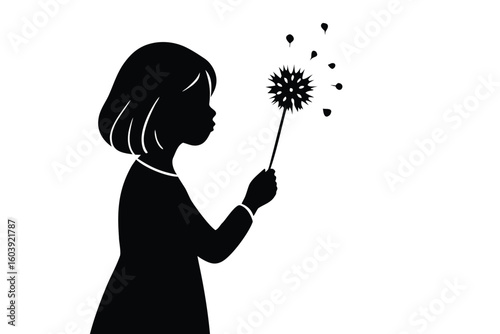 Silhouette of a young girl blowing on a dandelion