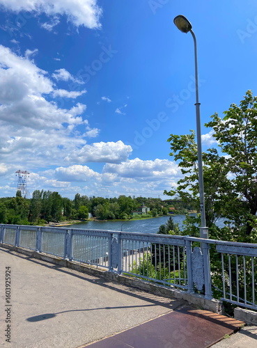 View of a comfortable pedestrian bridge across the Dnipro connecting the city of Dnipro with Monastyrsky Island on a hot sunny day.
